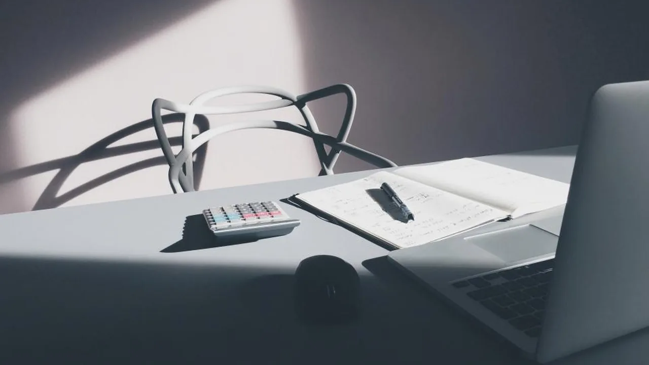 A notebook, calculator and figures on a business desk