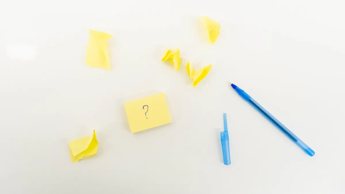 Yellow sticky notes and a blue pen on a white surface