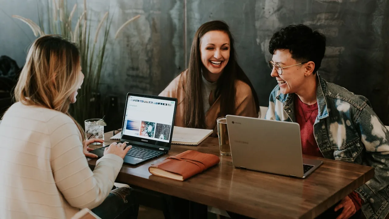 People collaborating around laptops comparing options