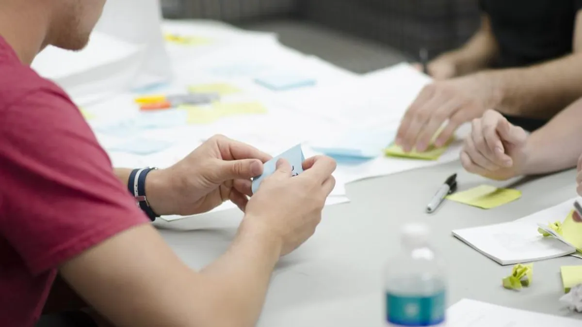 Colleagues planning with sticky notes around a table