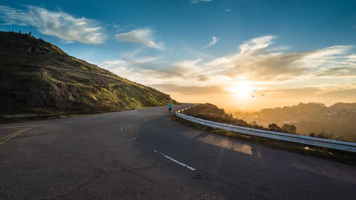 A winding road through hills at sunset