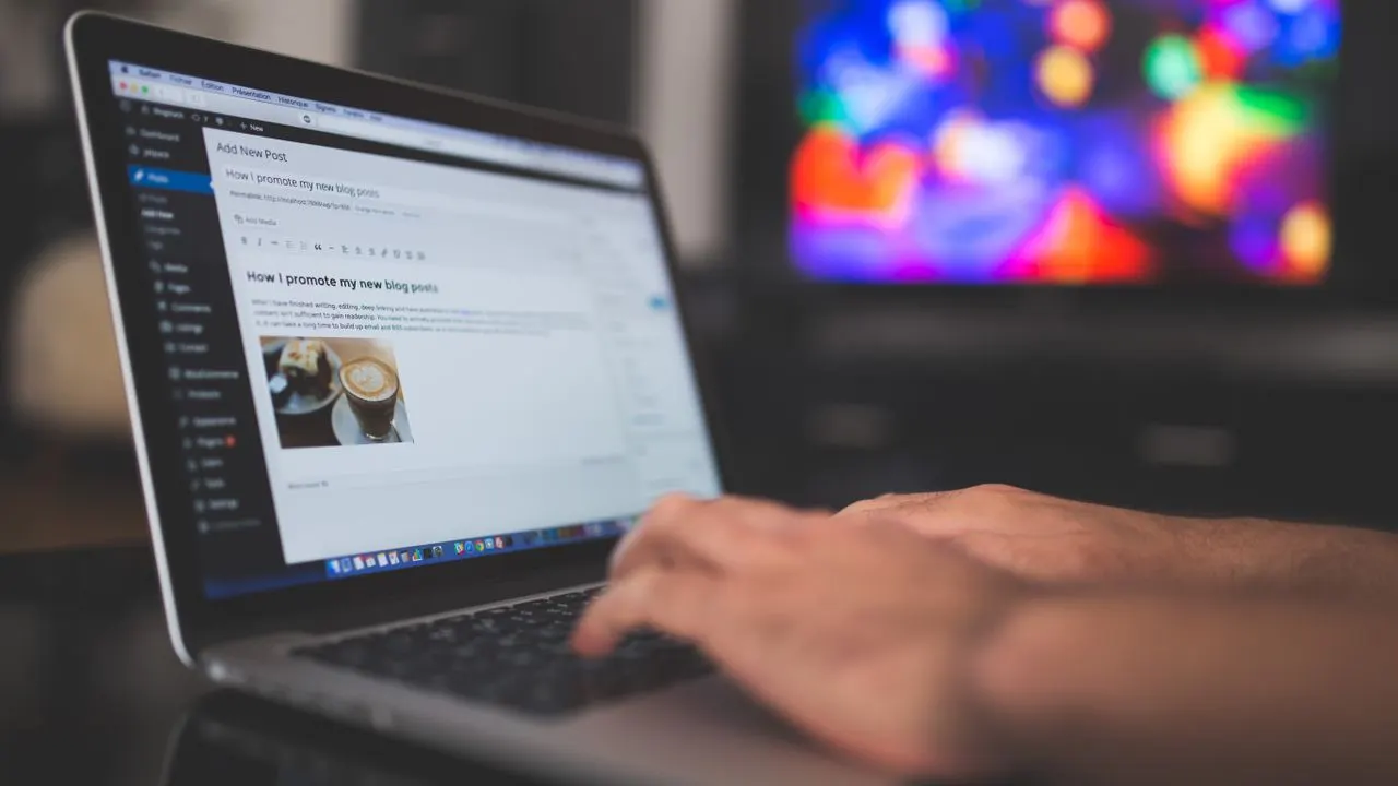 A person writing a blog post on a laptop