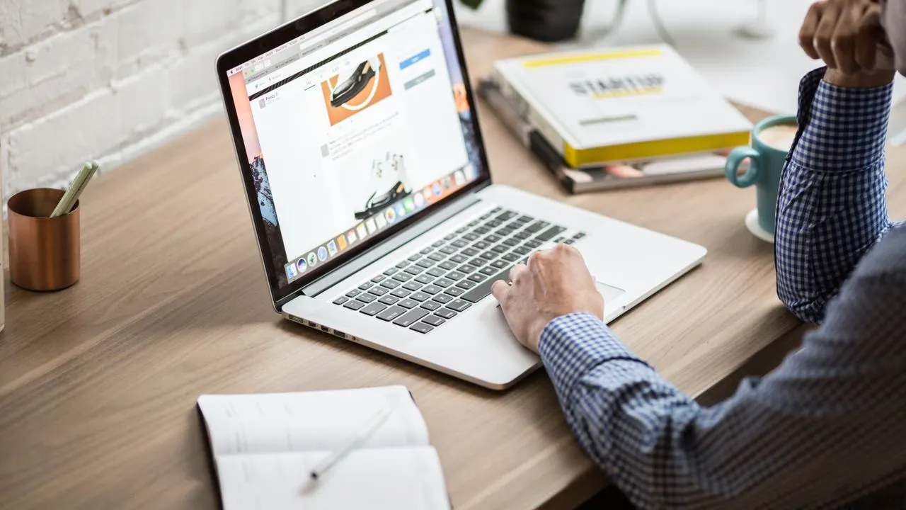 A person studying on a laptop at a tidy desk