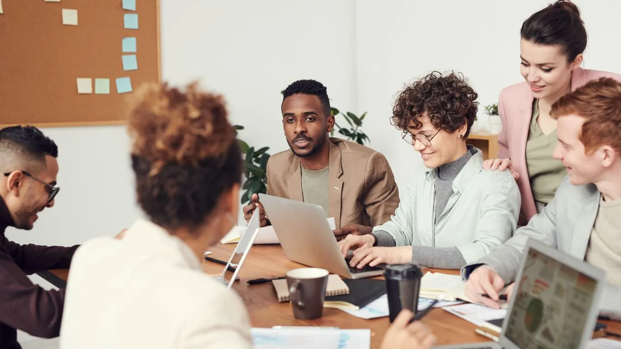 Young professionals working together around a laptop in a modern office