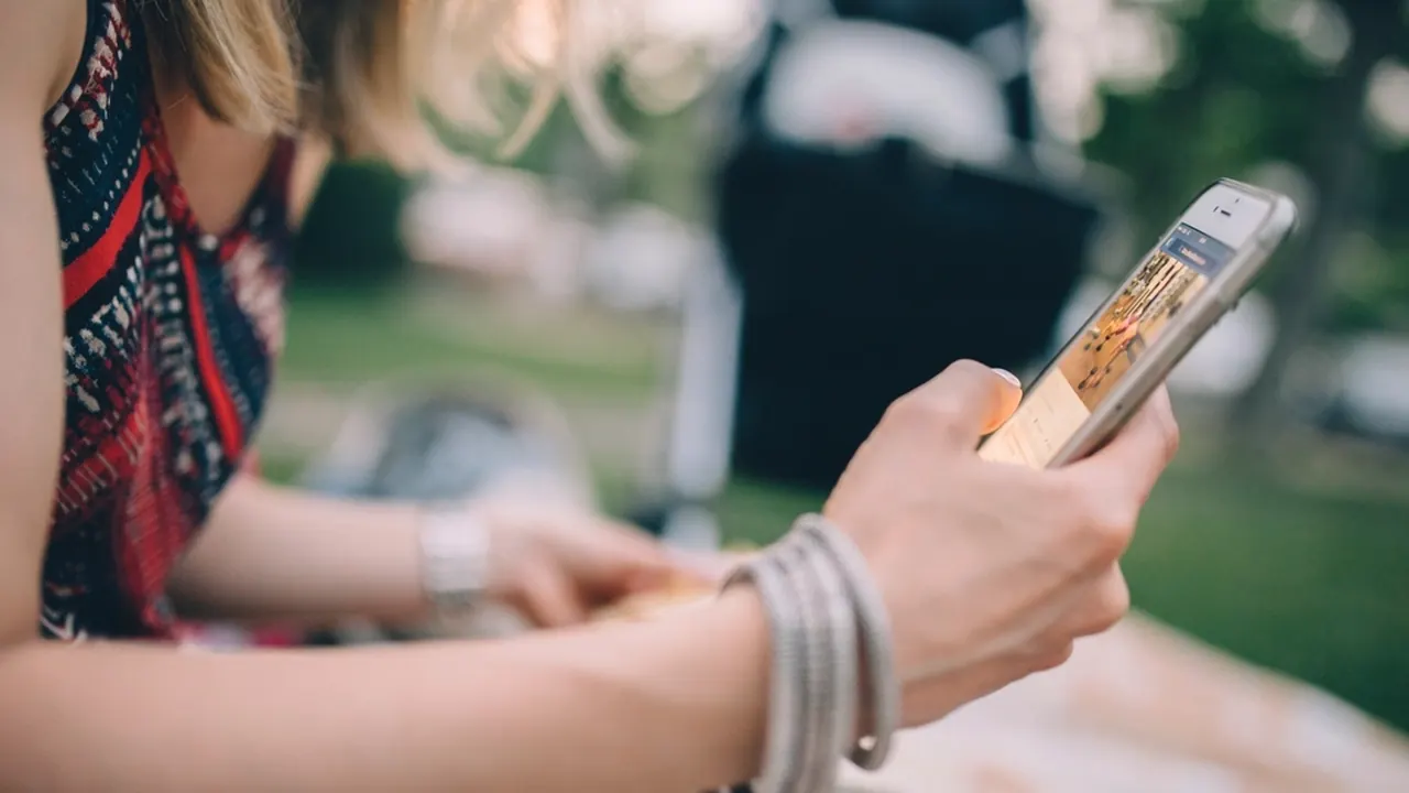 A woman scrolling on her smartphone outdoors