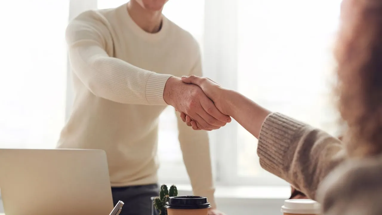 A handshake across an office desk