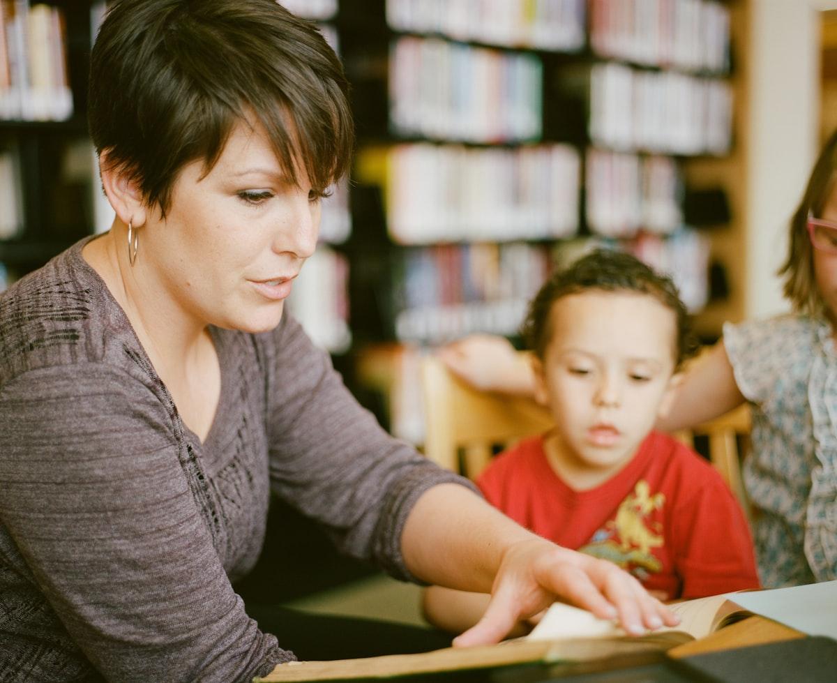 A tutor sitting beside a student, providing early, individual guidance before small gaps become large ones