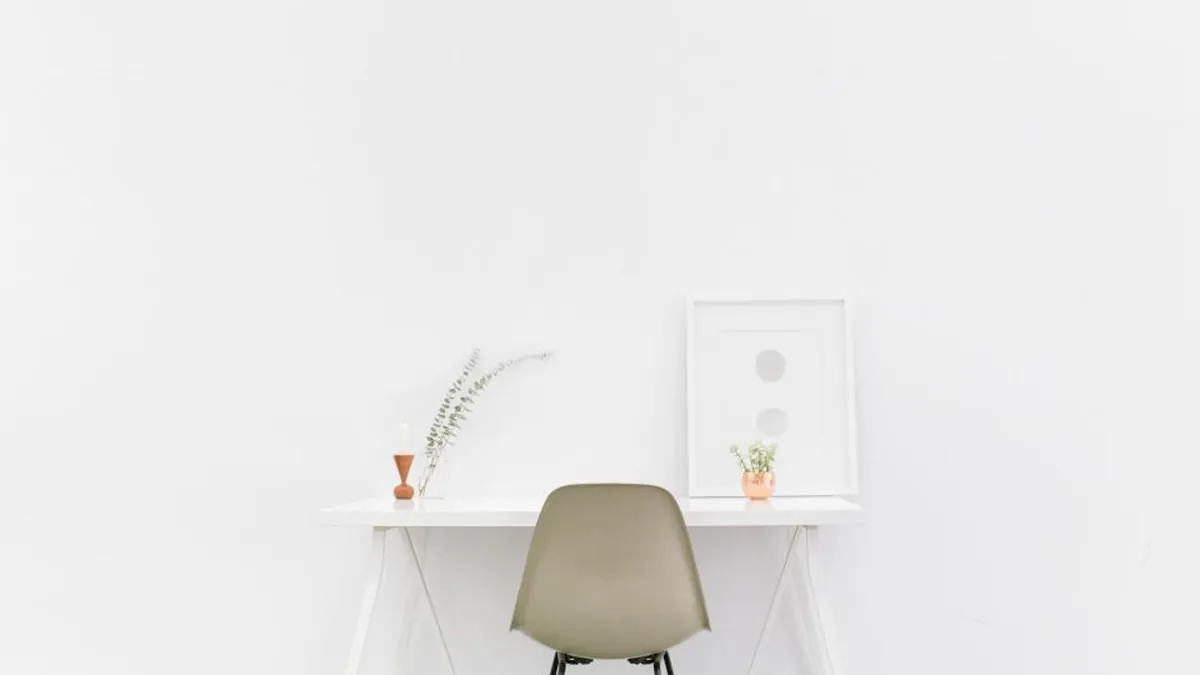 A minimal empty desk and chair in a bright room
