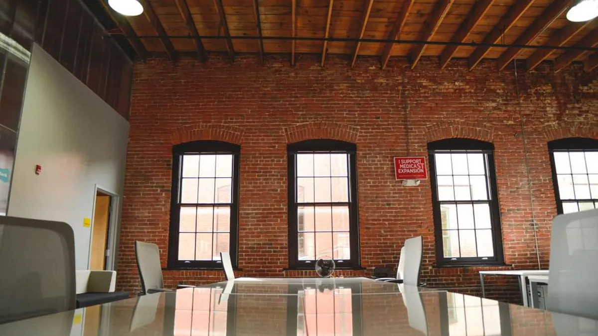 An empty open-plan startup office with brick walls