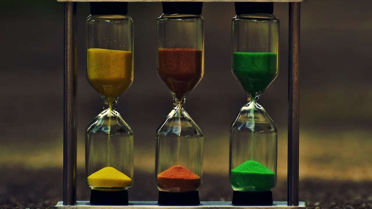 Three hourglasses with coloured sand running through them