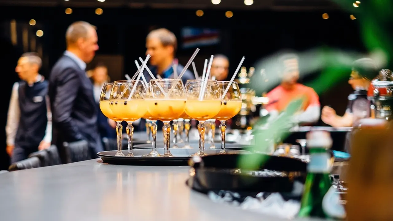 Guests talking around a bar at an evening industry event