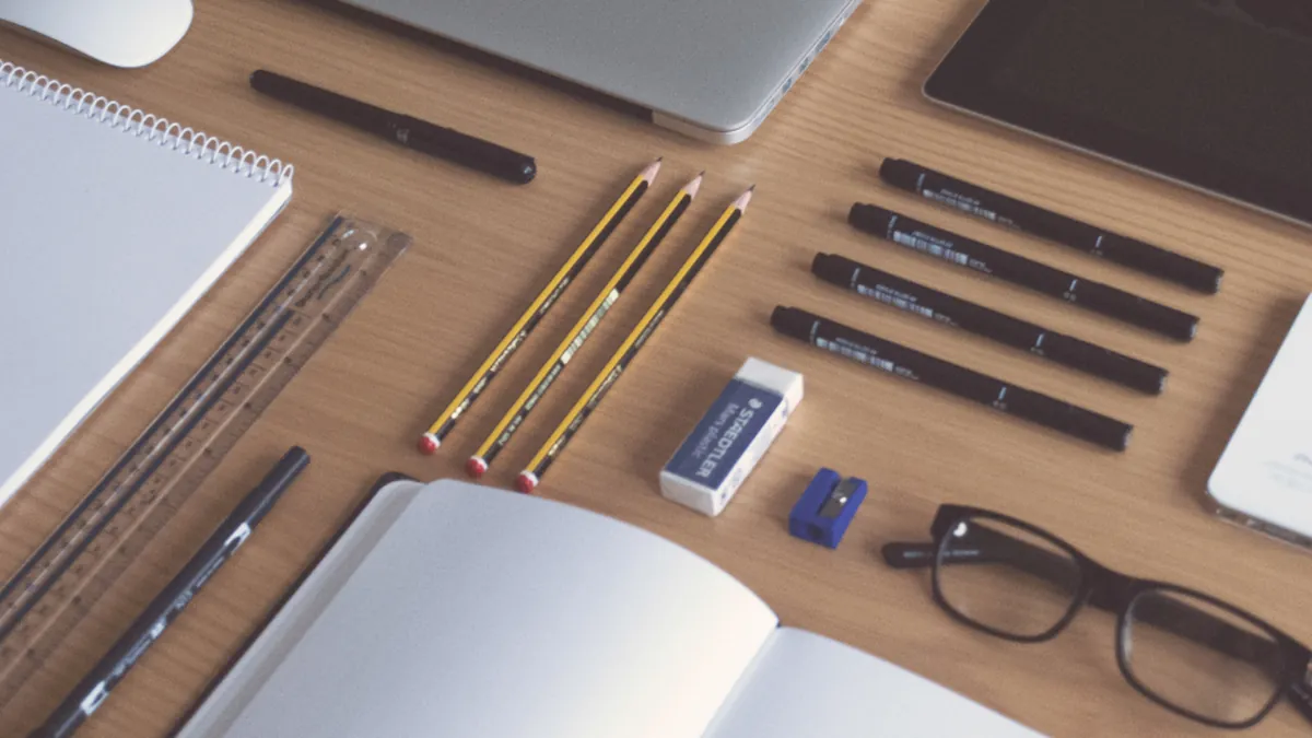 A tidy desk with notebooks, pencils and glasses ready for planning