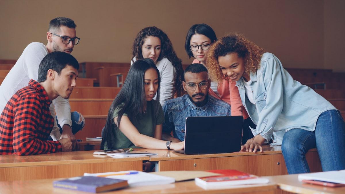 A diverse group of students collaborating on a laptop — international learners are a central part of London's business education community