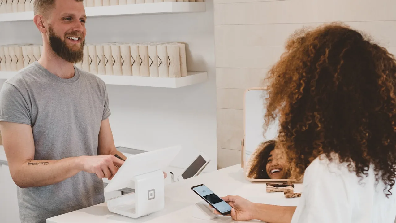 A boutique checkout with a customer paying by phone