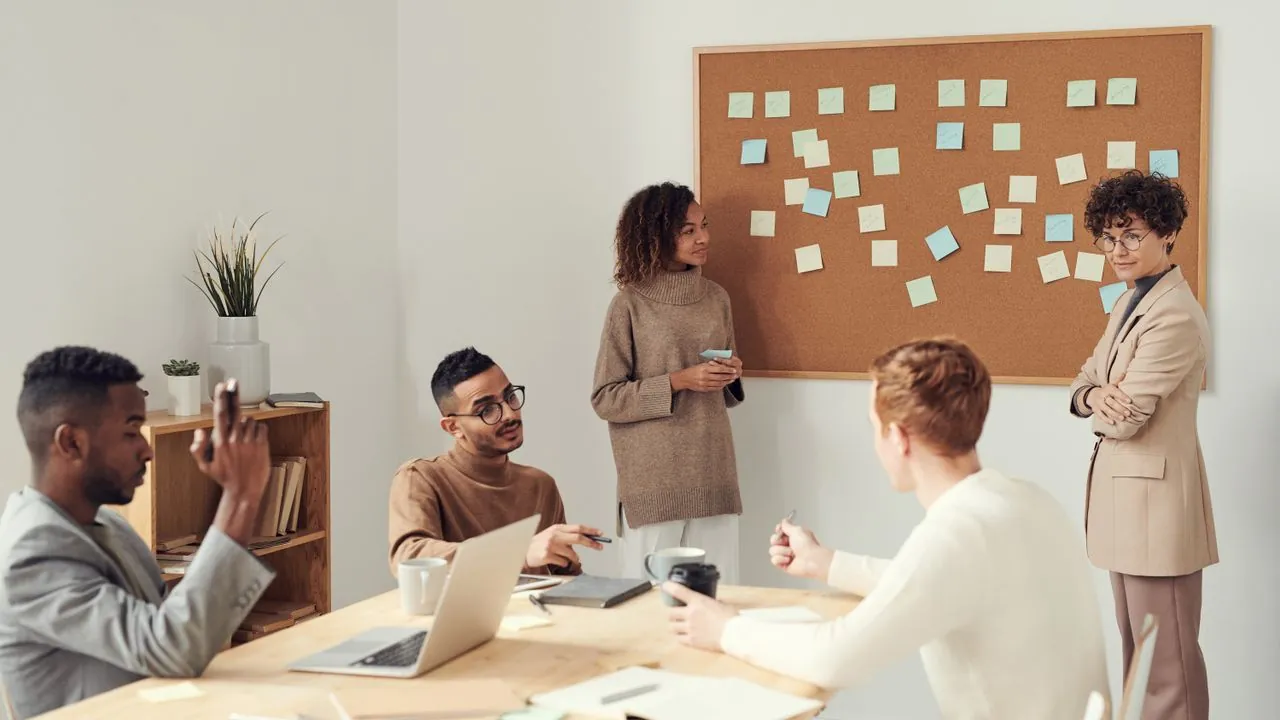 Colleagues from different teams meeting around a table
