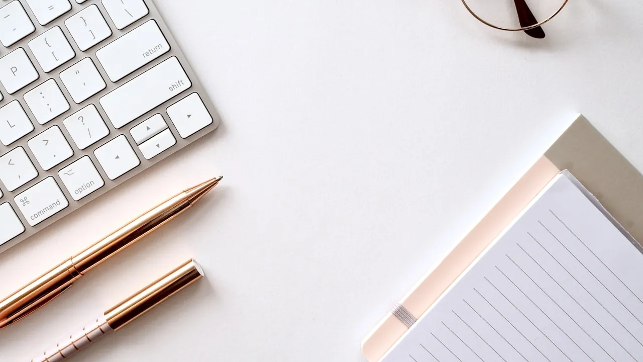 Coins and a laptop on a desk representing pay
