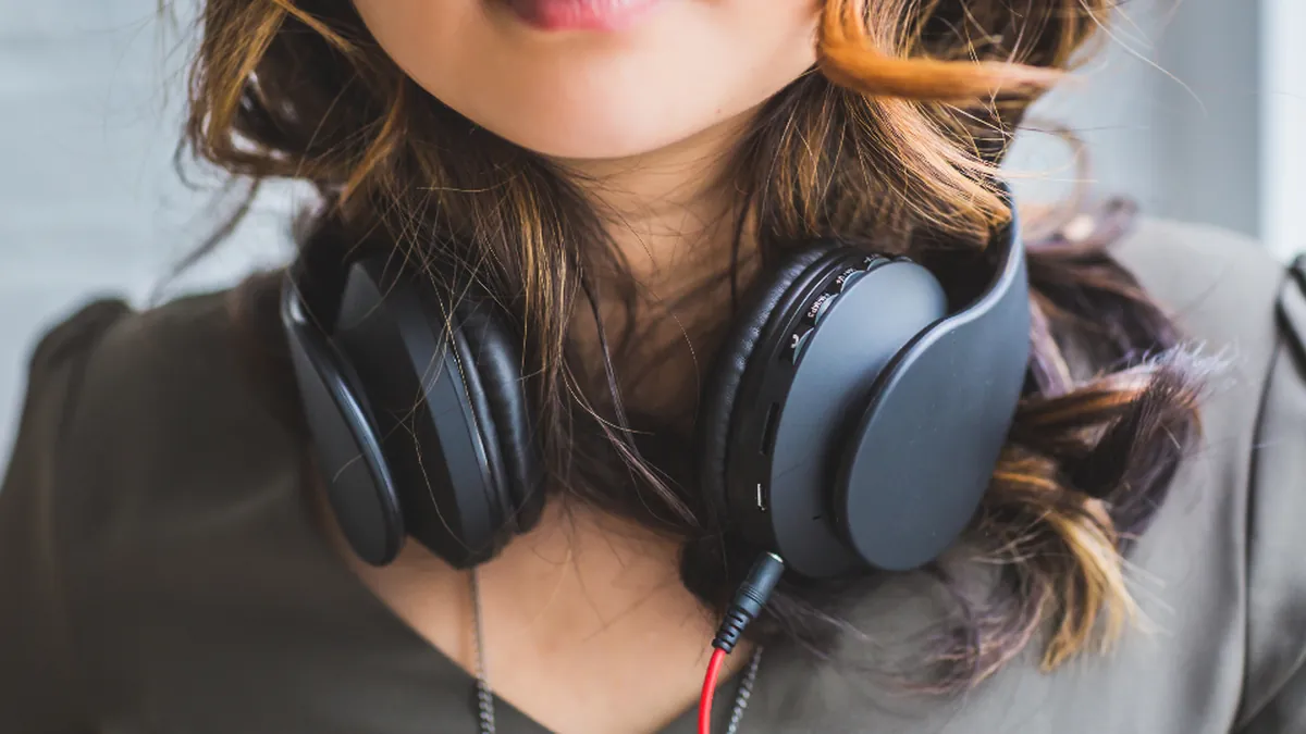 A woman wearing headphones around her neck