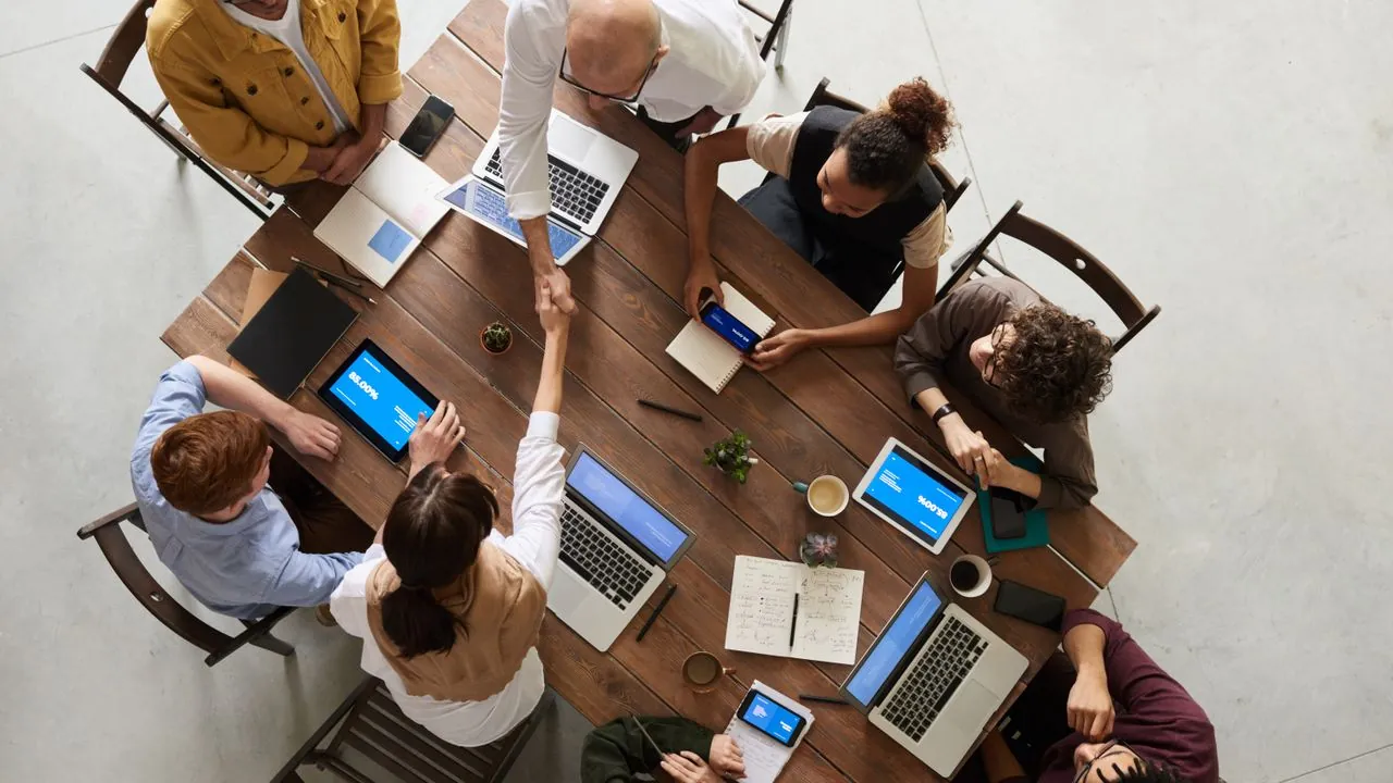 A business handshake across a meeting table