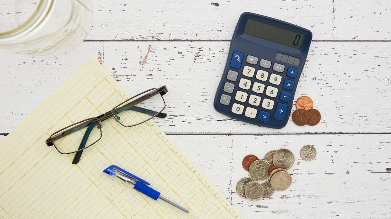 Person budgeting relocation costs with a calculator
