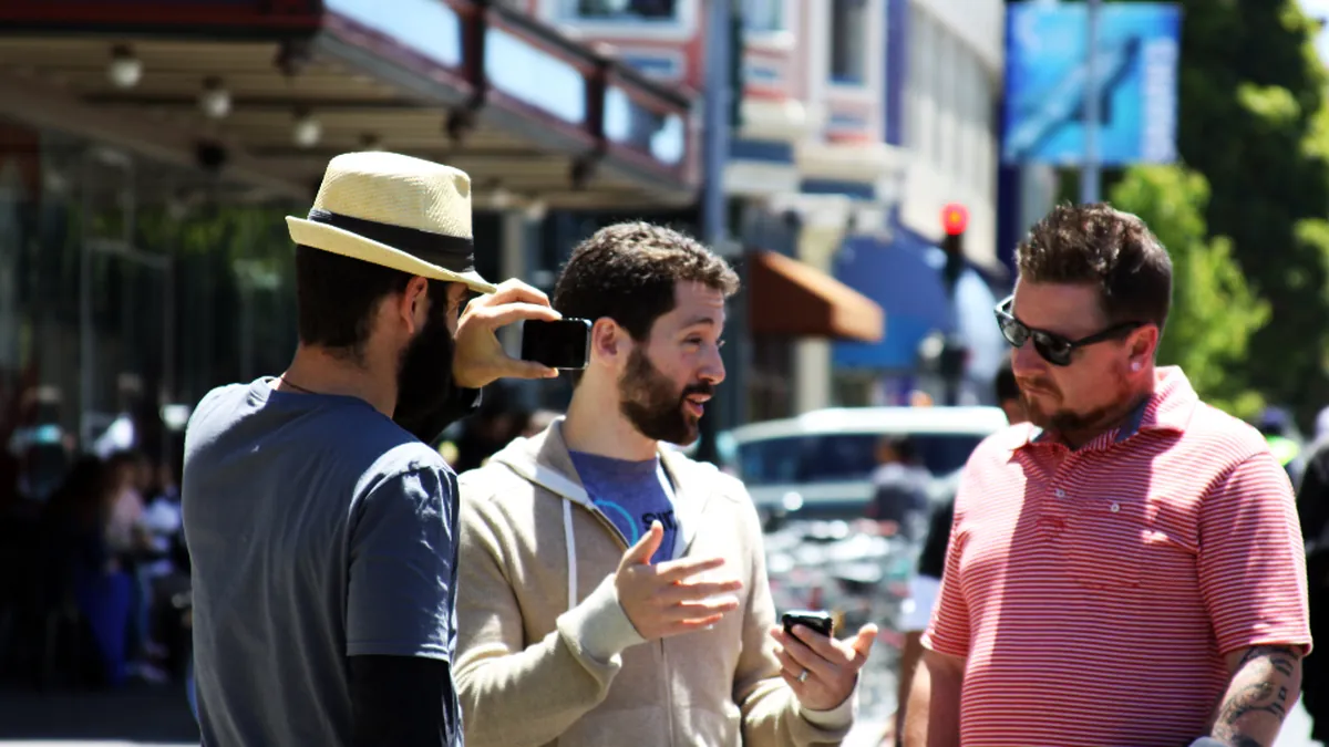 Three colleagues talking together outdoors