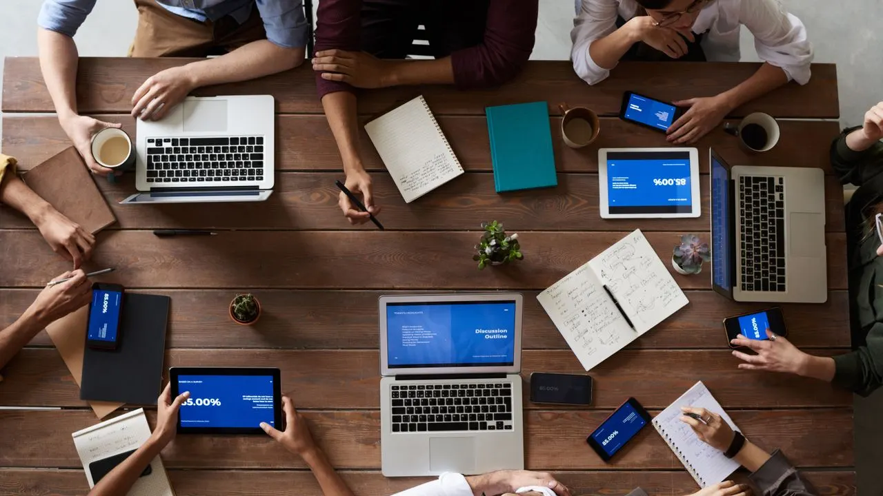 A team table covered in laptops and devices