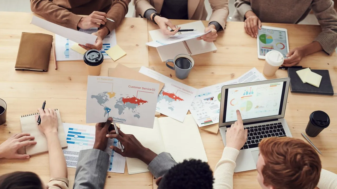 A marketing team collaborating over documents and a laptop