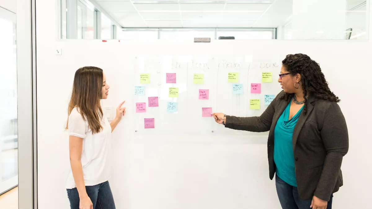 Two colleagues planning at a whiteboard